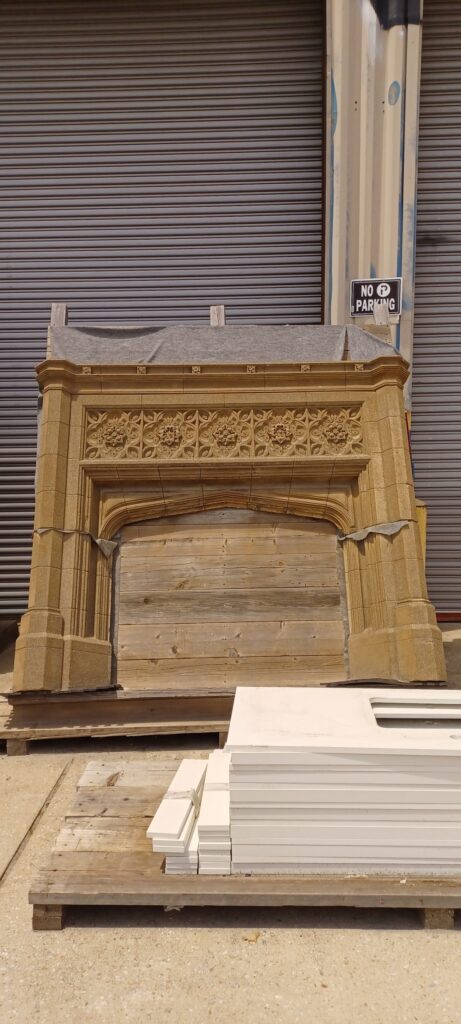 Salvaged ornate stone fireplace surround with carved floral patterns and reclaimed wood interior. Unique secondhand building materials and vintage decor from Second Chance, a Baltimore non-profit.