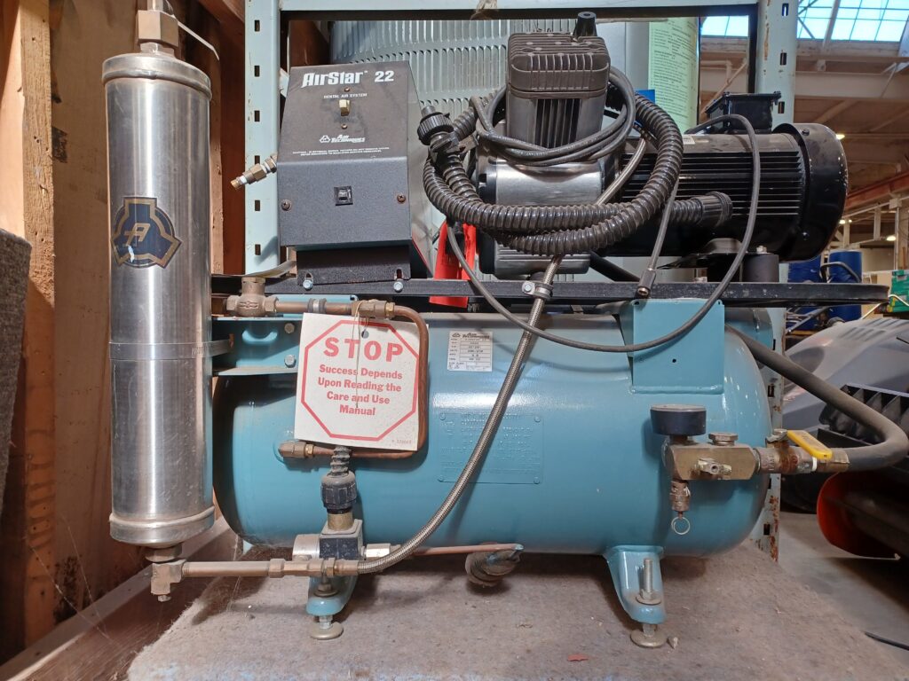 Salvaged AirStar 22 secondhand industrial air compressor with light blue tank and silver cylinder, available at Second Chance, a Baltimore non-profit offering used equipment and building materials.